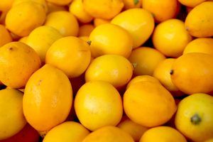 Pile of ripened Meyer Lemons that are bright yellow.